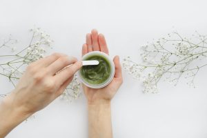 Young Female hands using green natural cream for face or body. organic natural skincare products